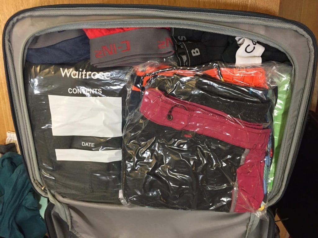 Half of a hand-luggage packed with clothes 