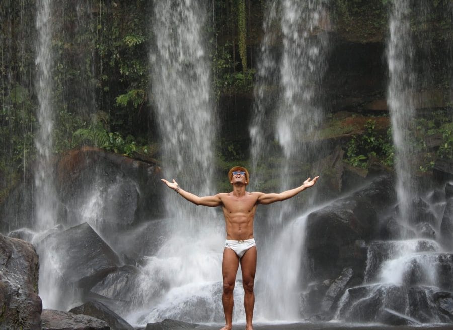 10 Healthy Lifestyle Tips That Everyone Can Follow in 2023 9 Pericles Rosa wearing a hat, blue sunglasses and a white speed with his arms wide open in Kulen Mountain, Camboja