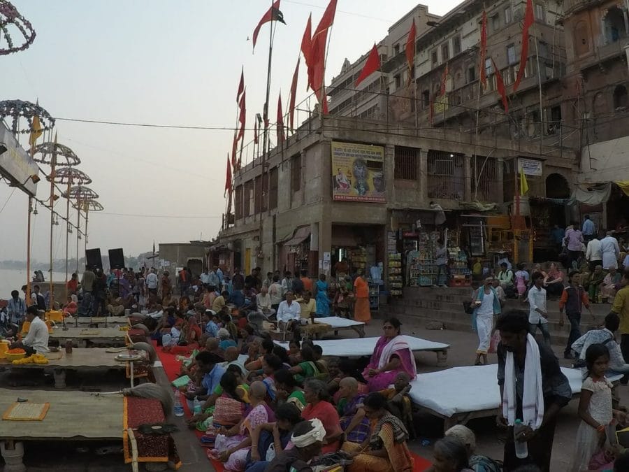 people seating on the Ganges river banks waiting for the Ganga Arti ceremony