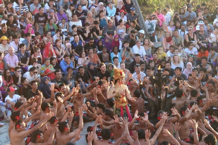 Spectators watching the Kecak Dance in Bali, Indonesia, performed at Uluwatu Temple during the sunset and the dancers in the middle of the stage