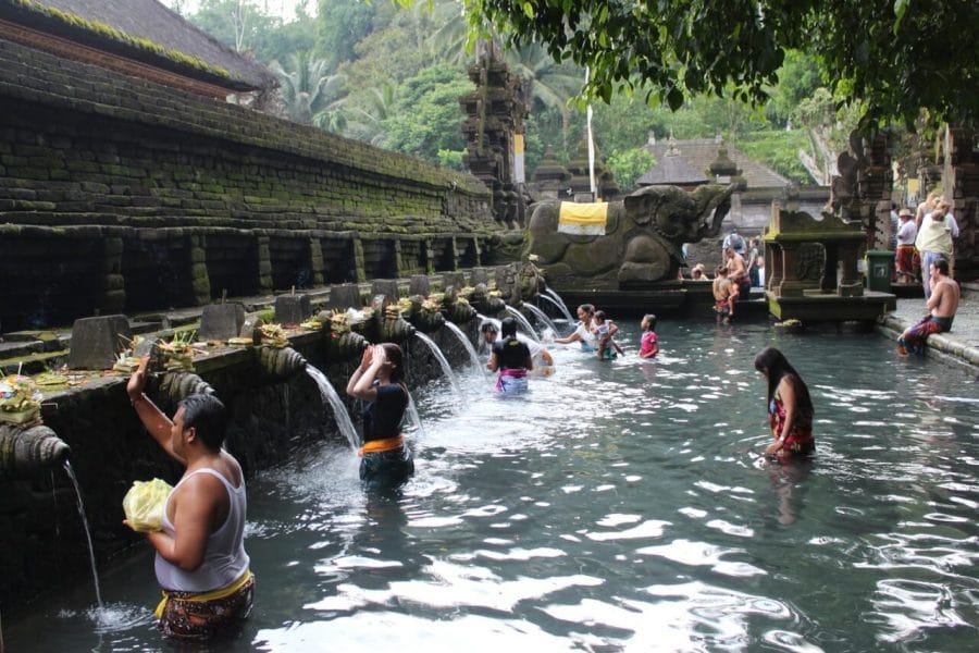 People in the water and having a bath in the fountains and praying at the Holy Spring Water Temple in Bali, Indonesia