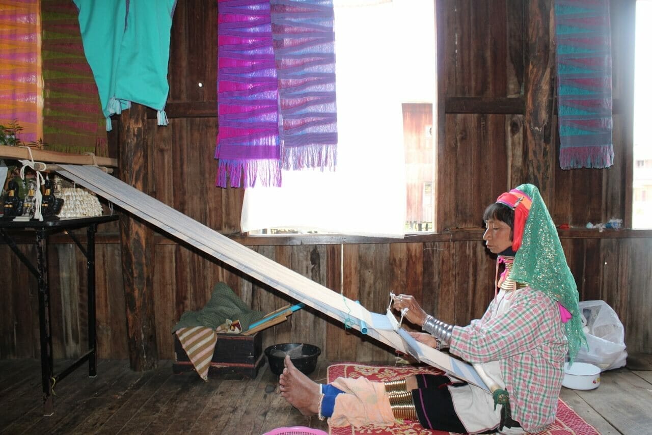 Uma 'mulher-girafa" trabalhando em uma fábrica de tecelagem no Lago Inle, Mianmar