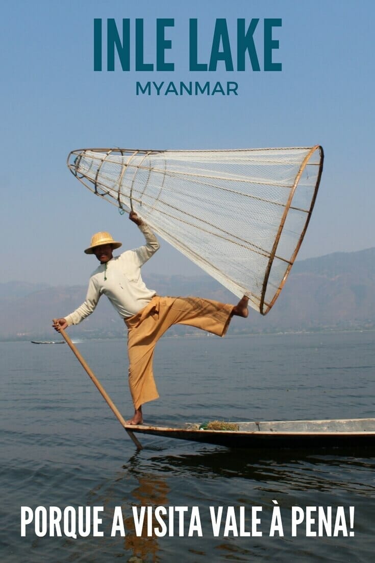 Um pescador com as pernas abertas segurando uma cesta em forma de cone no Lago Inle, Myanmar