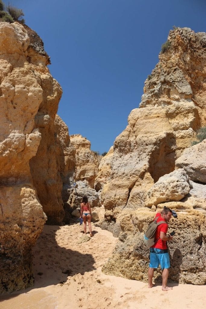 7 Most Beautiful & Best Beaches in Albufeira 7 A man and a woman walking among the cliffs at Praia de São Rafael, Albufeira, Portugal