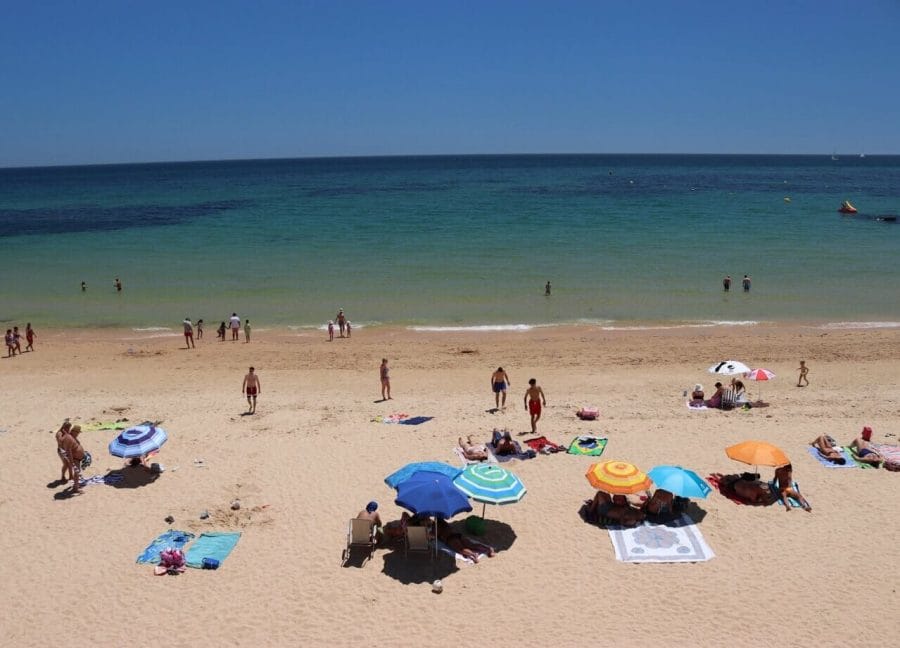 People sunbathing and walking on Praia de Santa Eulália, Albufeira, Portugal