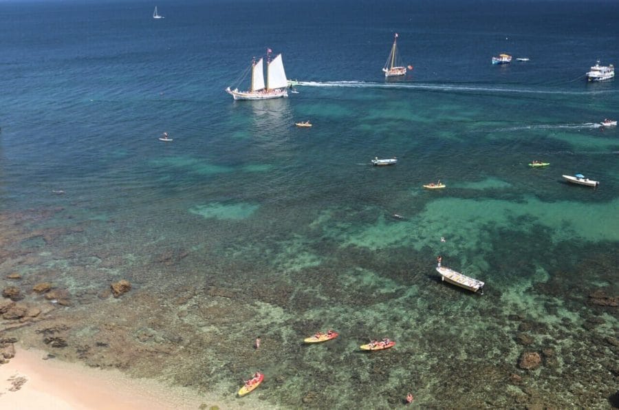 Barcos y kayaks, algunos arrecifes de coral y las cristalinas aguas azules de Praia Grande, Lagos, Portugal