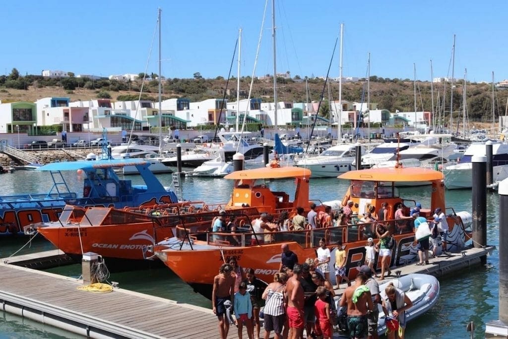 Many boats berthed in the Marina de Albufeira, and people leaving an orange tour boat 