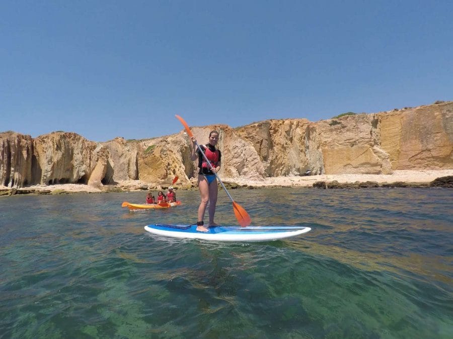 Que Ver en el Algarve con Niños: 12 Actividades para Toda la Familia 9 Una mujer haciendo SUP y duas niñas y un hombre en un kayak en la Praia dos Arrifes, Albufeira