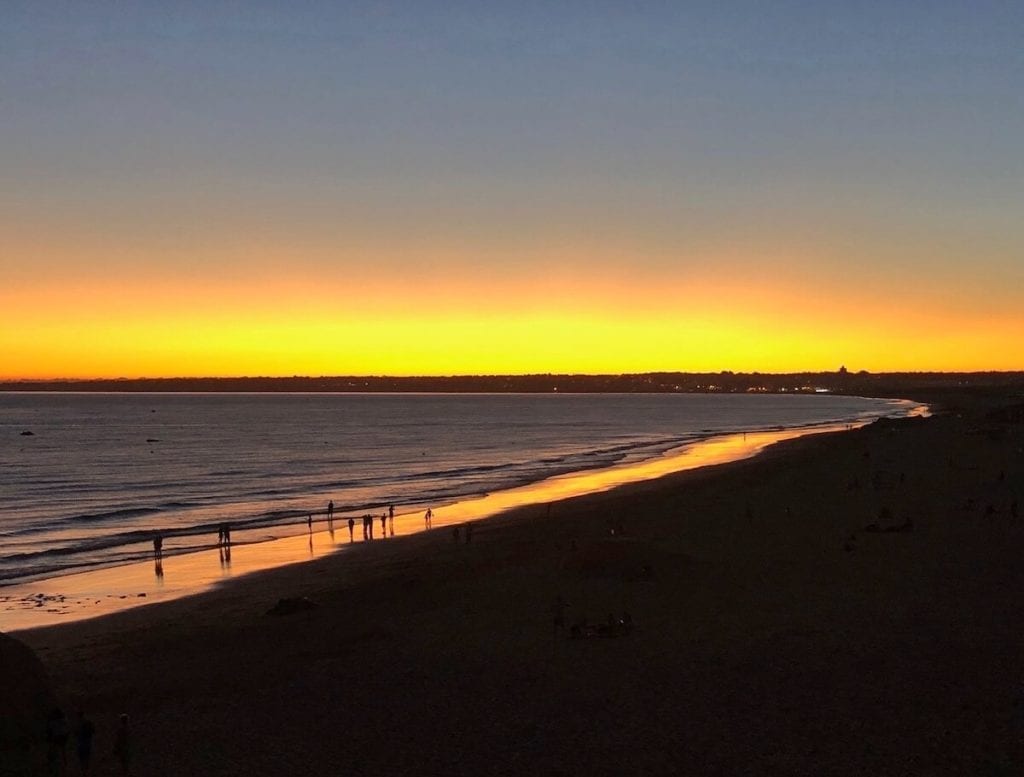 Praia da Galé, Albufeira, after the sunset with the sky and par of the sand coloured with vibrant shades of gold