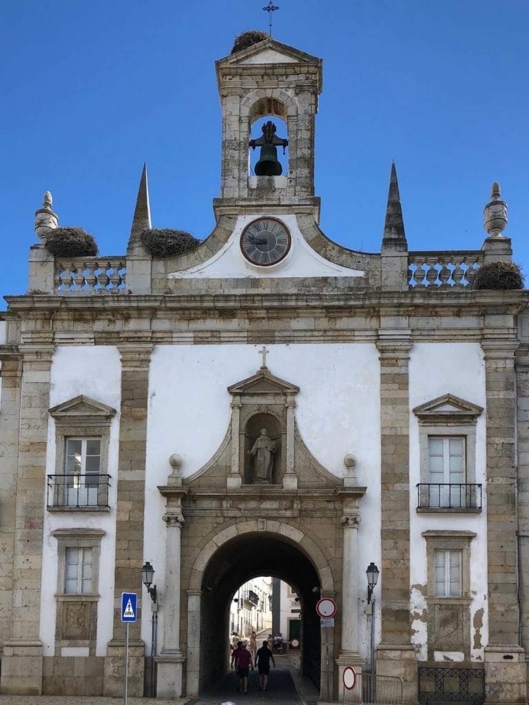 Arco da Vila, Faro, Portugal in neoclassical style has on the top a statue of St. Thomas Aquinas and right above,  a beautiful bell tower