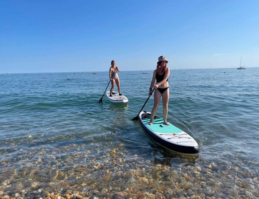 Duas mulheres fazendo stand up paddle board em Brighton Beach