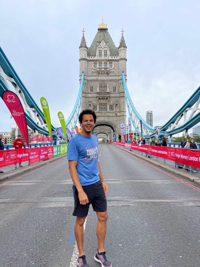 10 Healthy Lifestyle Tips That Everyone Can Follow in 2023 3 Pericles Rosa wearing a blue t-shirt and black shorts running at Tower Bridge, London