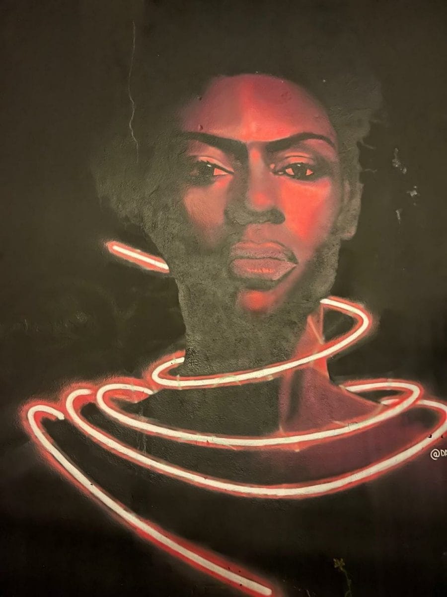 Shoreditch Street Art: Best Streets & Murals 2023 + Map 11 A neon pink face portrait mural of a woman by David Speed on Braithwaite St, London
