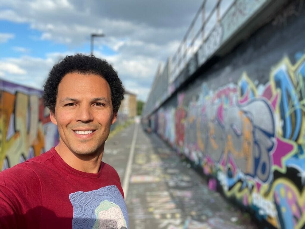 Péricles Rosa tirando uma selfie com os murais de grafite em Shoreditch, Londres