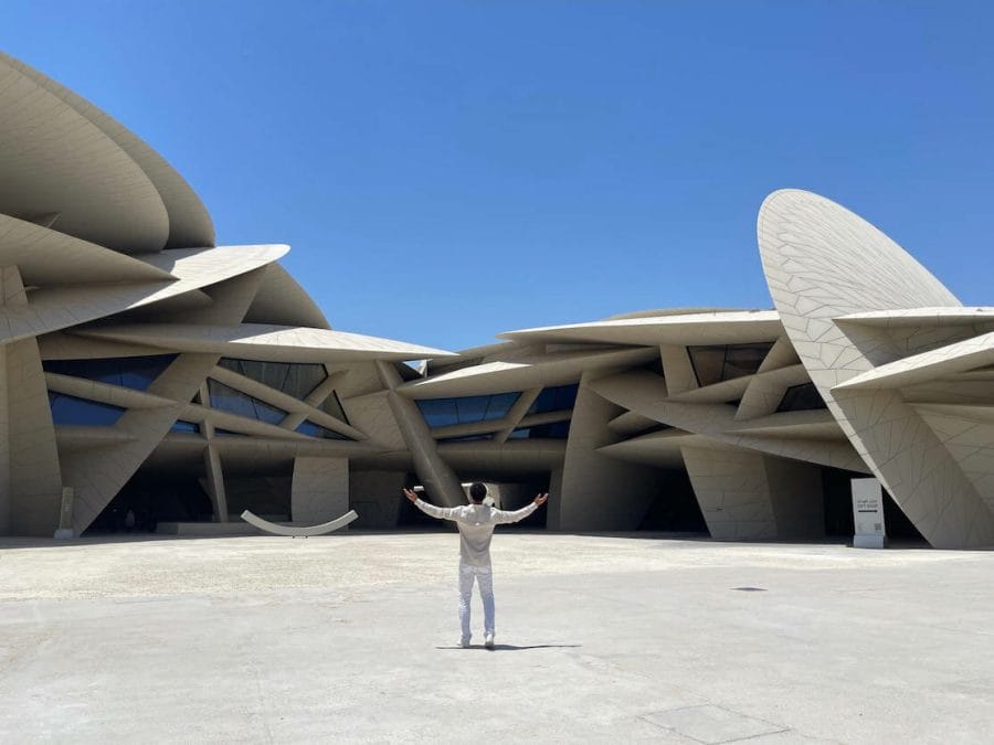 Doha Travel Tips - 15 Things to Know Before Travelling to Qatar 1 A man with the arms wide open in front of the National Museum of Qatar