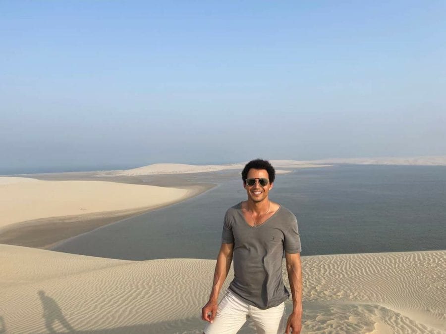 Pericles Rosa on the dunes of the Mesaieed Desert in Qatar with the Inland Sea in the background