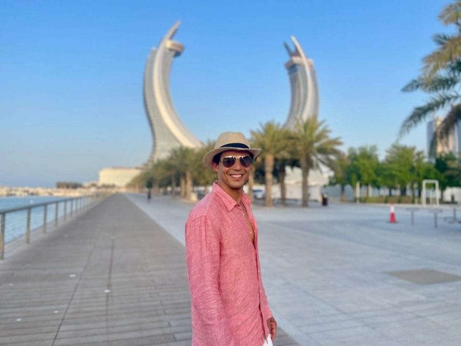 Pericles Rosa wearing sunglasses, a hat and a salmon shirt posing for a picture at Lusail Marina Promenade, Qatar