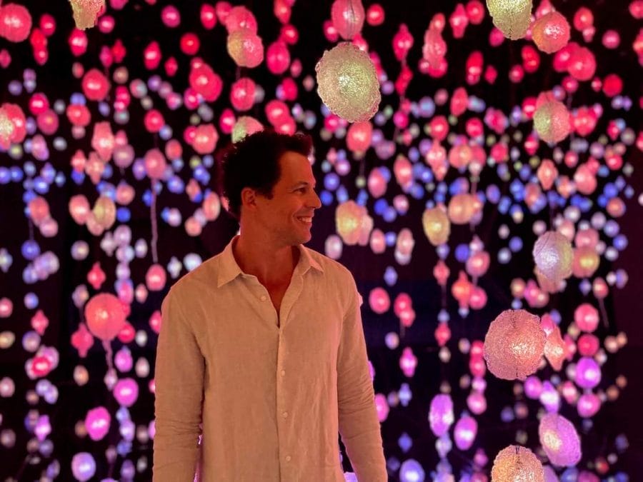 Pericles Rosa surrounded by colorful hanging crystal during the Pipilotti Rist Exhibition at National Museum of Qatar, Doha