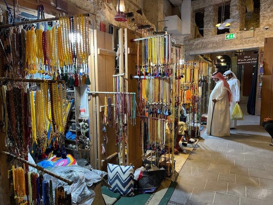 Two men wearing traditional costumes shopping at Souq Waqif, Doha, Qatar