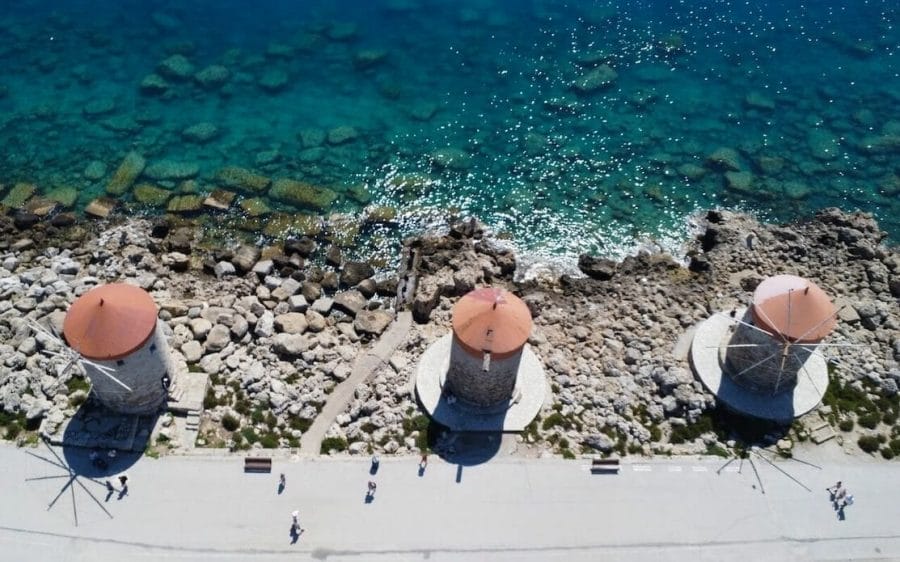Aerial view of people walking along the three windmills by the sea, Rhodes, Greece